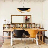 CATELLANI & SMITH Lederam Manta S1 LED-Pendelleuchte in schwarz gold über einem Besprechungstisch