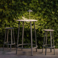 Vibia Mayfair Mini 5495 Akku Tischleuchte in Grün auf einem Gartentisch