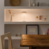 Vibia Mayfair Mini 5495 Akku Tischleuchte warmweiss beleuchtet ein Regal