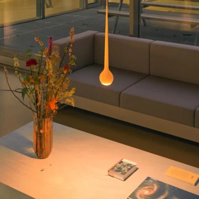 GRAU Falling Sun LED-Pendelleuchte Sun Orange über einem Tisch