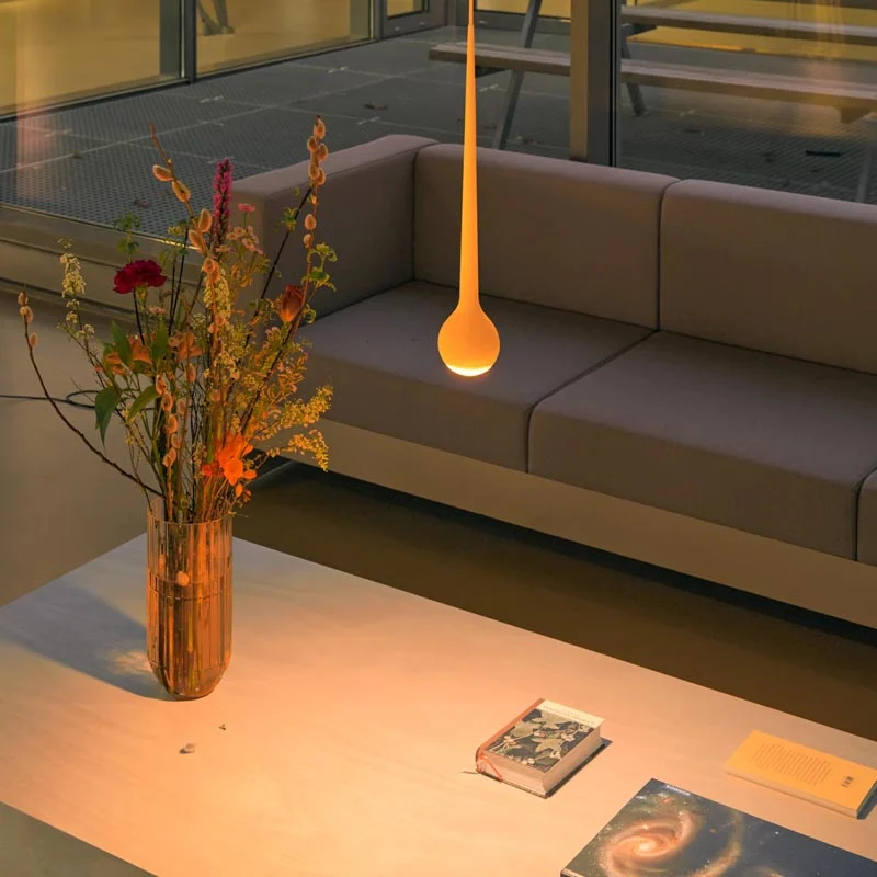 GRAU Falling Sun LED-Pendelleuchte Sun Orange über einem Tisch